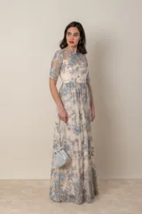 Vestido largo de gasa color marfil con bordado de hilo de seda en tonos celeste y avena. Modelo recto con corte en la cintura, manga corta y ruedo terminado en blonda.