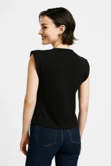 Blusa blanca de algodón, corte al cuerpo y cuello redondo.