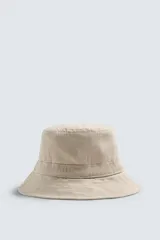 Sombrero tipo bucket color beige confeccionado en tejido de algodón con efecto lavado.