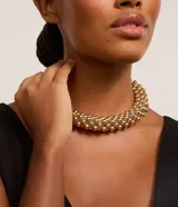 Maxi collar dorado con múltiples esferas de plástico metalizado.