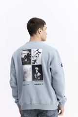 Buzo blanco de algodón con cuello redondo, puños y bolsillos laterales. Presenta un estampado en la espalda con cuatro imágenes de plantas en tonos sepia y texto.