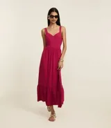 Vestido midi evasê sin mangas color fucsia, confeccionado en tejido airflow con textura arrugada. Presenta escote corazón, breteles medianos con elásticos, recortes fruncidos en la cintura y en el bajo, y cierre lateral con cremallera invisible.