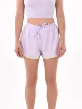 Short deportivo lila con cintura elástica ajustable con cordón y ribete amarillo flúor.