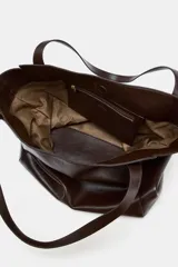 Bolso tipo maxi shopper de hombro, con diseño amplio y estructura flexible. Cuenta con doble asa de hombro con detalle de pespuntes, cierre mediante botón imantado y bolsillo interior con cremallera.