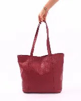 Bolso tote de cuero color bordó, con broche de cierre, bolsillo interior y porta llaves.