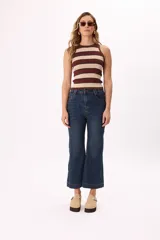 Pantalón jean negro de tiro medio con pierna ancha acampanada y corte cropped.