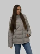 Campera puffer color gris, con cuello alto y capucha desmontable. Cierre frontal con cremallera y bolsillos laterales con cierre. Diseño acolchado y detalles distintivos de Calvin Klein.