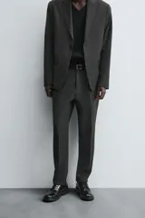 Pantalón de vestir de corte slim fit, color gris oscuro con micro estampado a cuadros. Cuenta con bolsillos laterales y traseros de doble vivo con botón. Cierre frontal con cremallera y botón.