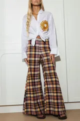Camisa blanca de lino con bordado de sol amarillo con corazón en el bolsillo.