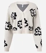Cardigan color crema con estampado de flores abstractas en negro, escote en V, cierre frontal con botones y mangas largas.