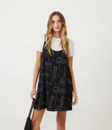 Vestido corto negro con estampado de palabras en blanco y remera blanca de manga corta con estampado de estrellas.