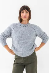 Sweater gris de punto con cuello redondo y mangas largas.