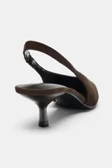 Zapato destalonado de mujer, color marrón oscuro, con acabado en punta, escote en pico y tira trasera con pieza elástica. Posee un tacón kitten de 6 cm.