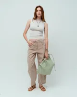 Pantalón jean slouchy color beige, 100% algodón teñido en prenda con efecto gastado vintage. Tiene pierna baggy con recorte lateral y pinza debajo de la rodilla, cintura elastizada en espalda, cartera con cierre metálico níquel, bolsillos laterales, dos bolsillos plaqué en espalda y uno en lateral izquierdo a la altura de rodilla. Tiro medio.