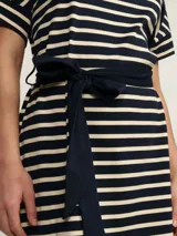 Vestido a la rodilla de algodón a rayas horizontales en color negro y beige, con cuello redondo, mangas cortas y cinturón azul marino.