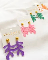 Par de aros colgantes con forma de hoja abstracta color lila y base dorada.
