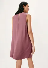 Vestido corto sin mangas color beige, de corte recto y cuello redondo.