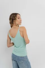 Musculosa amarilla de hilo con brillo sutil, de calce ajustado y breteles finos.