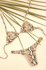 Bikini con top de triángulos ajustables y almohadillas removibles, acompañado de un bottom colaless con laterales fijos, en estampado de serpiente.