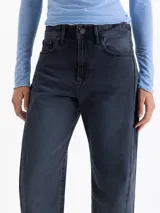 Jeans de denim con fit recto y tiro medio, en tonos grises azulados oscuros. El bajo es deshilachado.