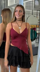 Minifalda negra de tiro bajo con volados y detalles brillantes.