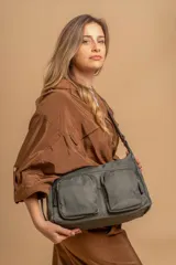 Bandolera de tafeta impermeable, liviana, con dos compartimientos principales, dos bolsillos con cierre y correa regulable con hebilla.