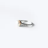 Anillo de plata 925 con perla de río central y circonias engarzadas en la alianza.