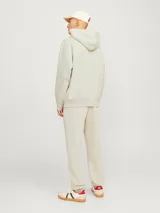 Hoodie color beige de manga larga y cuello con capucha. Tiene un fit holgado con bolsillo canguro.