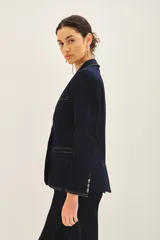 Blazer azul marino de denim con forro azul satinado, solapas de muesca, cierre frontal con un botón, bolsillos delanteros con solapa y puños con botones.