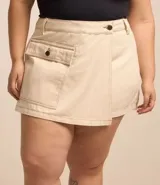 Short pollera de sarga color beige, con parte delantera cruzada, bolsillo con solapa delantero, bolsillos traseros y cintura con ajuste elástico interior.