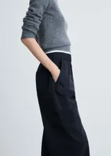 Pantalón negro de corte ancho con cintura elástica y cordón ajustable.