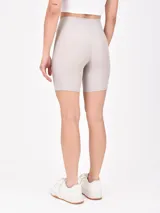 Short deportivo tipo biker de tiro alto, color terracota, con pretina cruzada en forma de V.