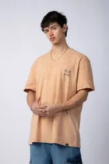 Remera color verde oliva con cuello redondo y mangas cortas, con un pequeño estampado en el pecho.