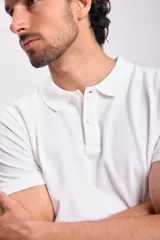 Remera polo blanca de piqué de algodón, con cuello clásico y tapeta de dos botones. Corte recto y mangas cortas.