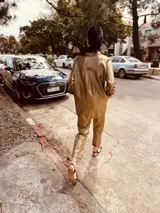 Pantalón de lino metalizado color dorado, de corte recto, con bolsillos laterales y traseros, y elástico en la cintura.