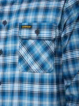 Camisa de manga larga con estampado a cuadros en tonos rojo, blanco, azul y gris. Tiene dos bolsillos en el pecho con cierre de botón, puños ajustables con botón y un paño de microfibra oculto en el dobladillo delantero.