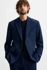 Blazer slim fit azul marino confeccionado en tejido con viscosa. Tiene cuello con solapas de muesca, manga larga con puño con botones, bolsillo de vivo en el pecho, bolsillos de solapa en la cadera, bolsillo interior y aberturas en la espalda.