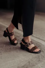 Sandalias de cuero con estampado de leopardo, taco medio ancho, tira ancha sobre los dedos y tira al tobillo con hebilla metálica.