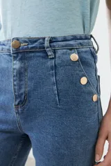 Pantalón jean culotte de tiro alto, color azul medio, con bolsillos delanteros y traseros, y botones metálicos.