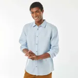 Camisa celeste de lino, de corte recto, con cuello clásico y mangas largas con puños abotonados.
