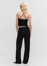 Pantalón de punto wideleg, color negro, con tiro alto y cierre lateral de cremallera, diseño largo.