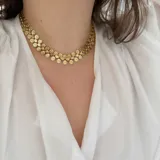 Collar dorado de acero quirúrgico hipoalergénico con baño en oro 18K. Formado por eslabones circulares con diseño de flor.