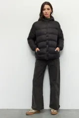 Campera puffer color verde oliva de nylon con capucha, cierre frontal y bolsillos laterales con cierre.