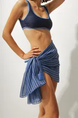 Pareo de playa con estampado a rayas verticales azules y negras.
