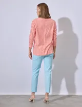 Remera de algodón con estampado a rayas horizontales y verticales en color naranja y blanco.