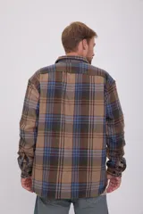 Sobrecamisa de manga larga a cuadros en tonos marrón, azul y verde. Tiene cierre con botones, bolsillos en el pecho con cierre de botón y corte relajado.