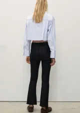 Pantalón de jeans negro con efecto encerado, tiro medio, corte bootcut y largo cropped.