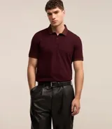 Polo de manga corta color borgoña, con cuello jacquard y tapeta de dos botones. Confeccionada en tejido de algodón.