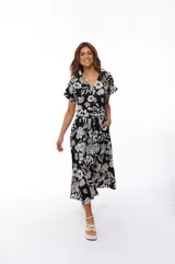 Vestido midi negro con estampado floral blanco, escote en V, mangas cortas y lazo en la cintura.