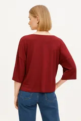 Remera negra de viscosa y elastano, manga 3/4 con botones en las mangas y cuello redondo.